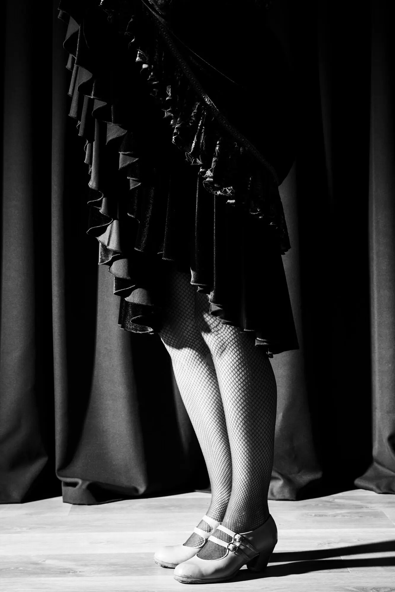 Schwarz-weiß: Frau zeigt trainierte Beine.