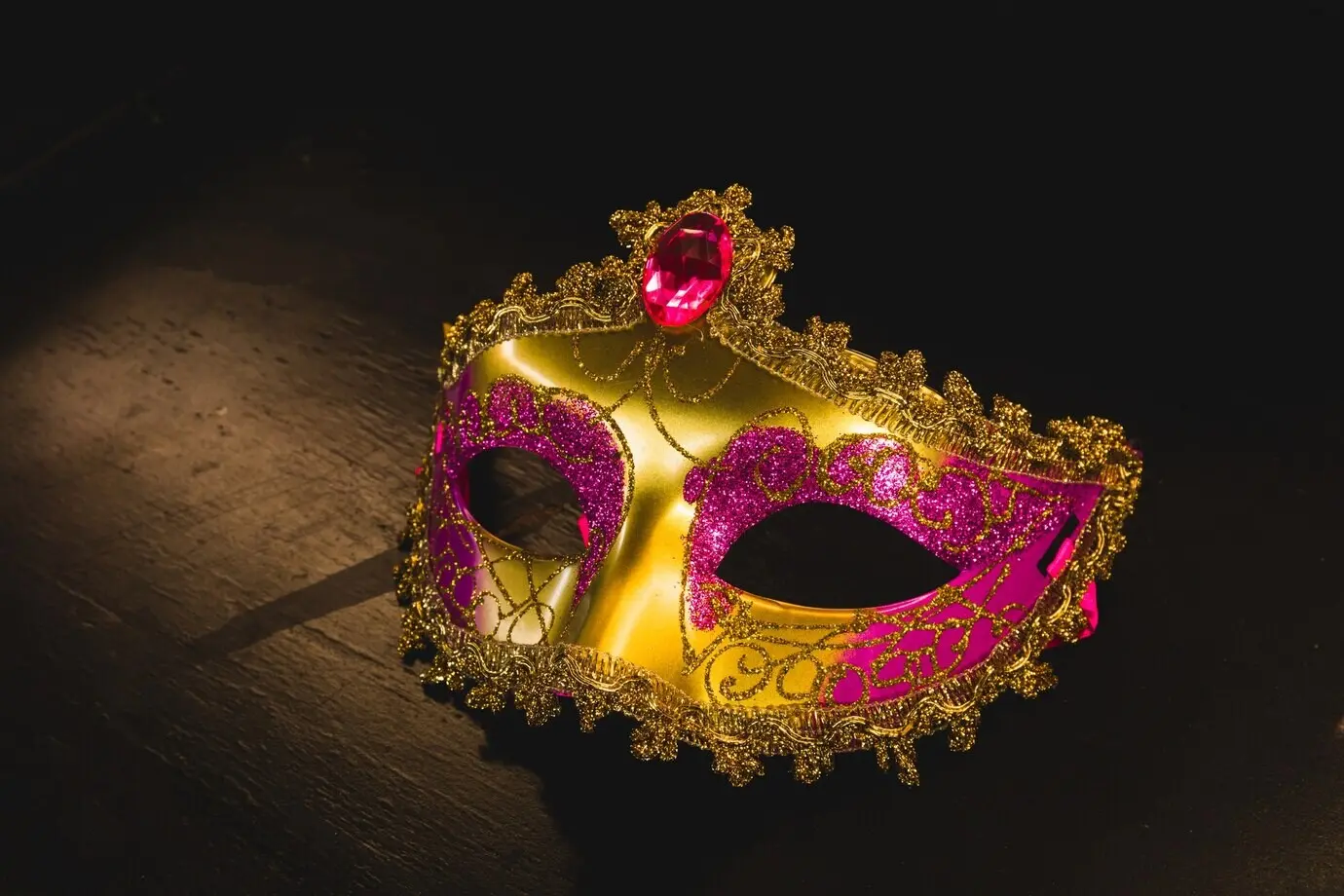 Goldene venezianische Maske auf einem Holztisch